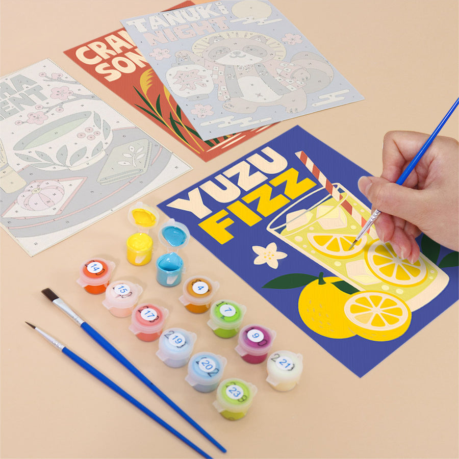 Hand painting a Kyoto Posters mini canvas of a lemon drink poster next to numbered paint pots