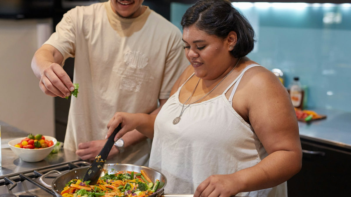 Couple cooking dinner together in their kitchen at home