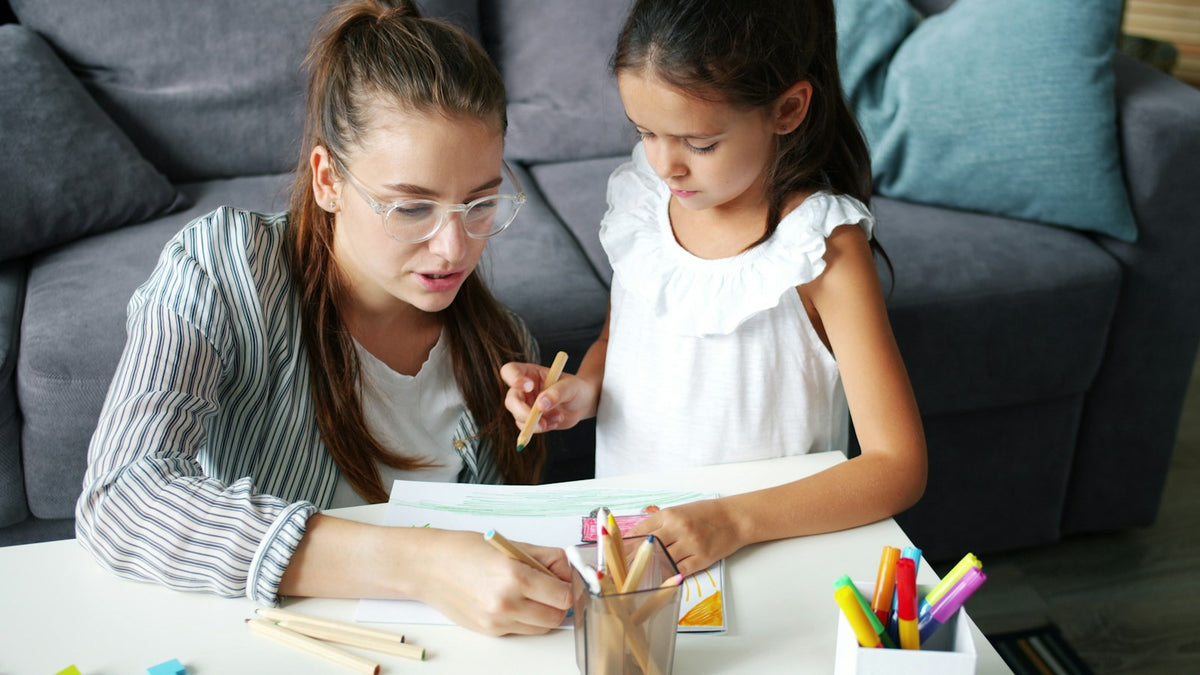 Mother and daughter sitting at a table drawing together
