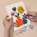 Hand holding an Abstract Figures mini canvas while painting the details