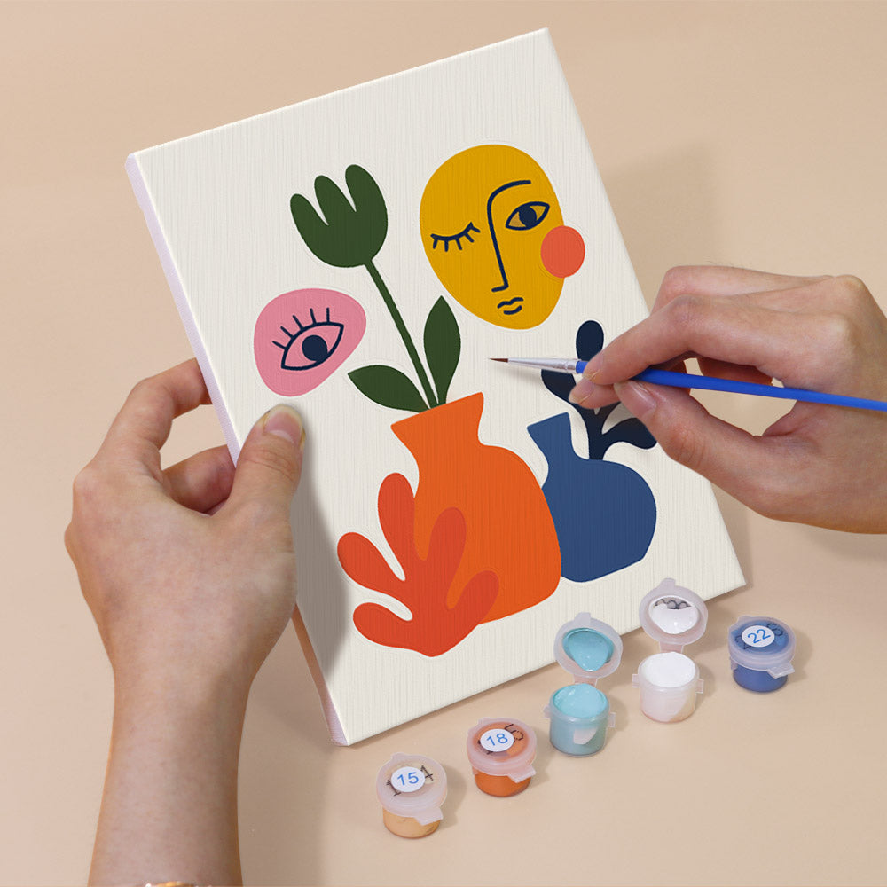 Hand holding an Abstract Figures mini canvas while painting the details