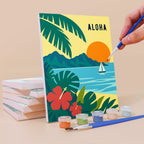 Painting an Aloha Horizons mini canvas propped up beside numbered acrylic paints