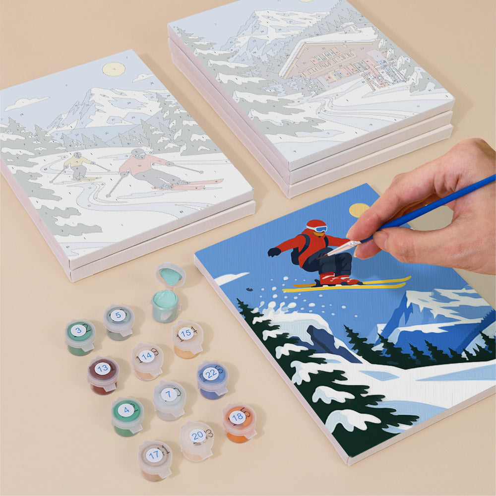 Painting one of the Alpine Ski Days designs next to a stack of mini canvases