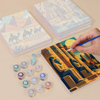 Painting one of the Ancient Egypt designs next to a stack of mini canvases