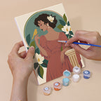 Hand holding an Art Nouveau Muses mini canvas while painting the details