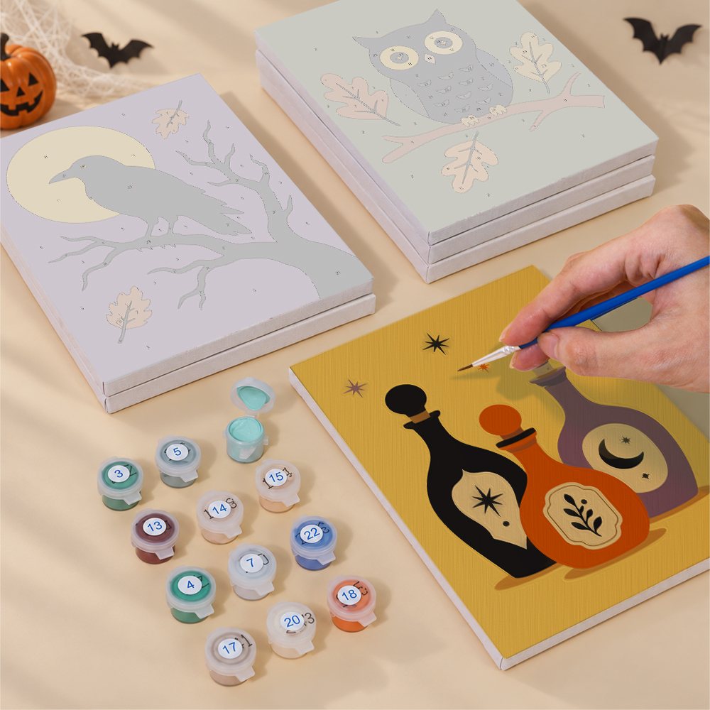 Painting one of the Autumn Apothecary designs next to a stack of mini canvases