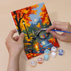 Hand holding an Autumn Rain Promenade mini canvas while painting the details