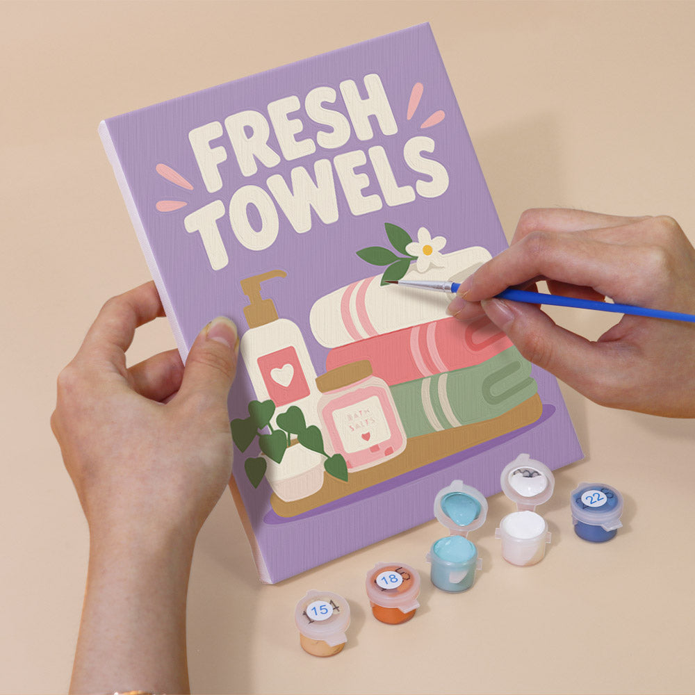 Hand holding a Bathroom Bliss mini canvas while painting the details