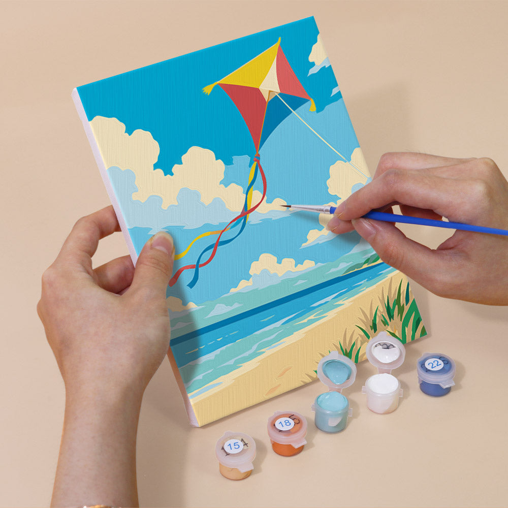 Hand holding a Beach Day mini canvas while painting the details