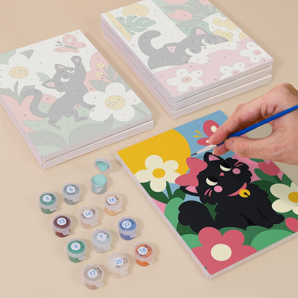 Painting one of the Black Cat Garden designs next to a stack of mini canvases