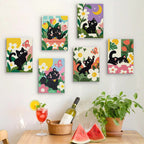 Six finished Black Cat Garden mini paintings hung on a wall above a table