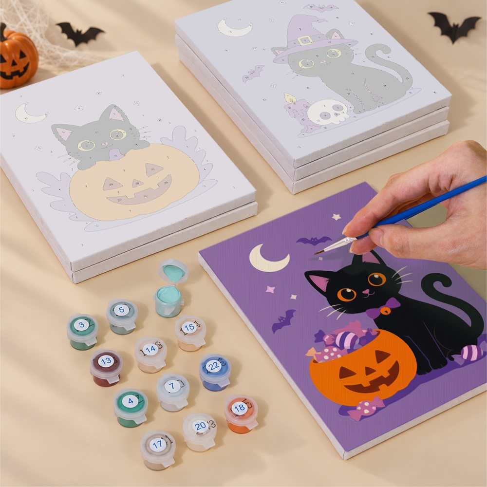 Painting one of the Black Cat Treats designs next to a stack of mini canvases