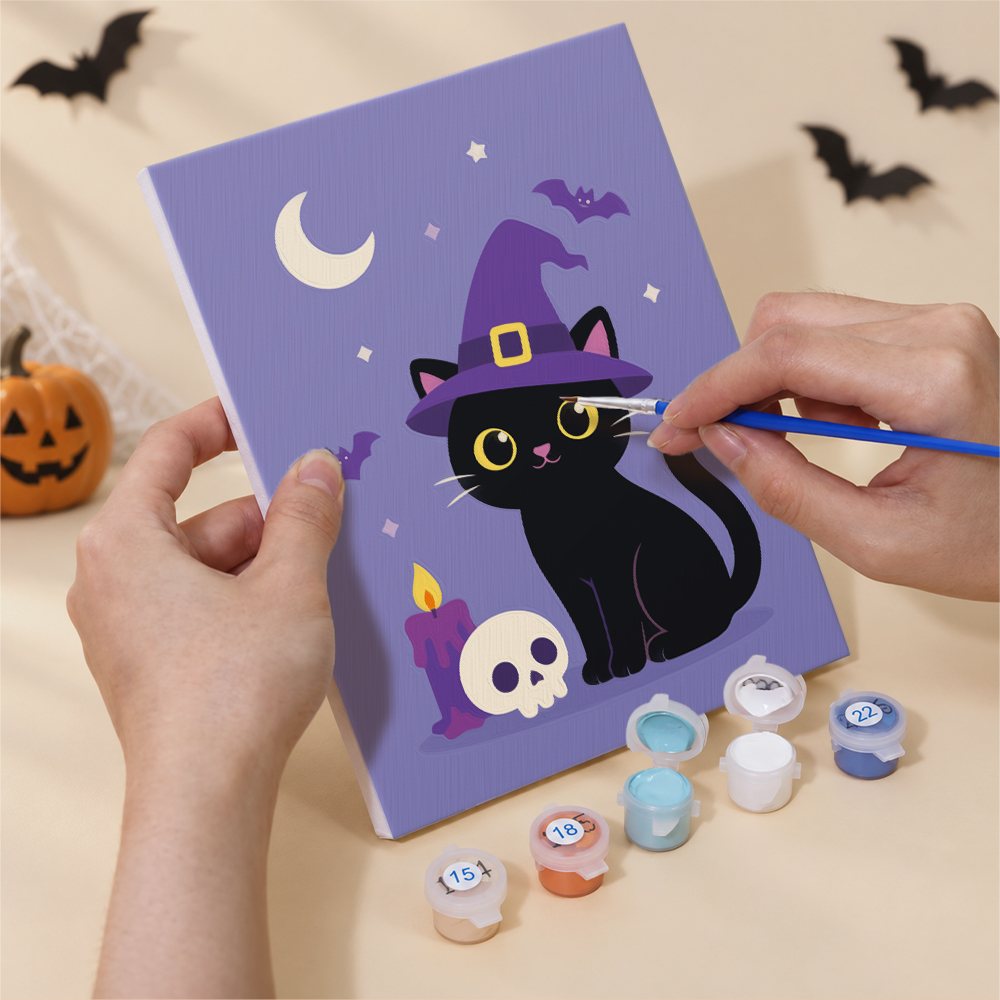 Hand holding a Black Cat Treats mini canvas while painting the details