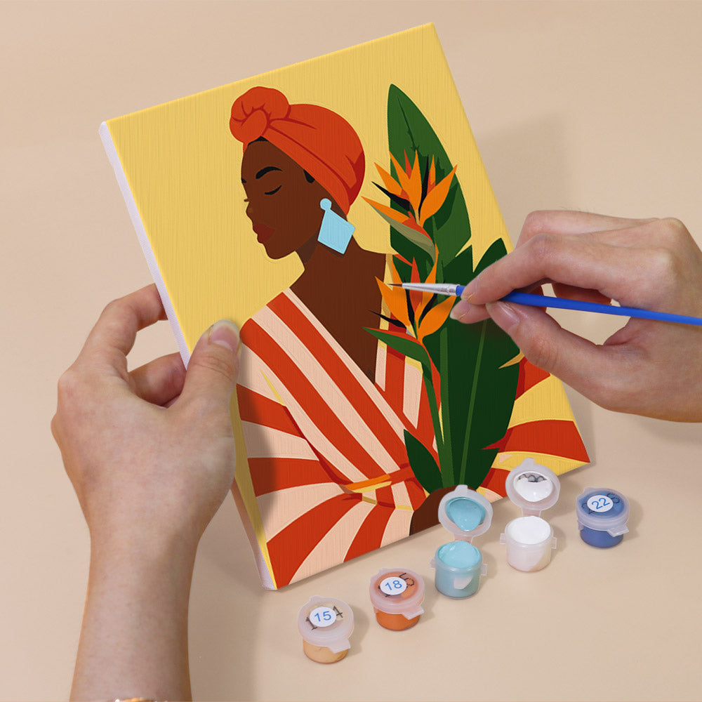 Hand holding a Blooming Muses mini canvas while painting the details
