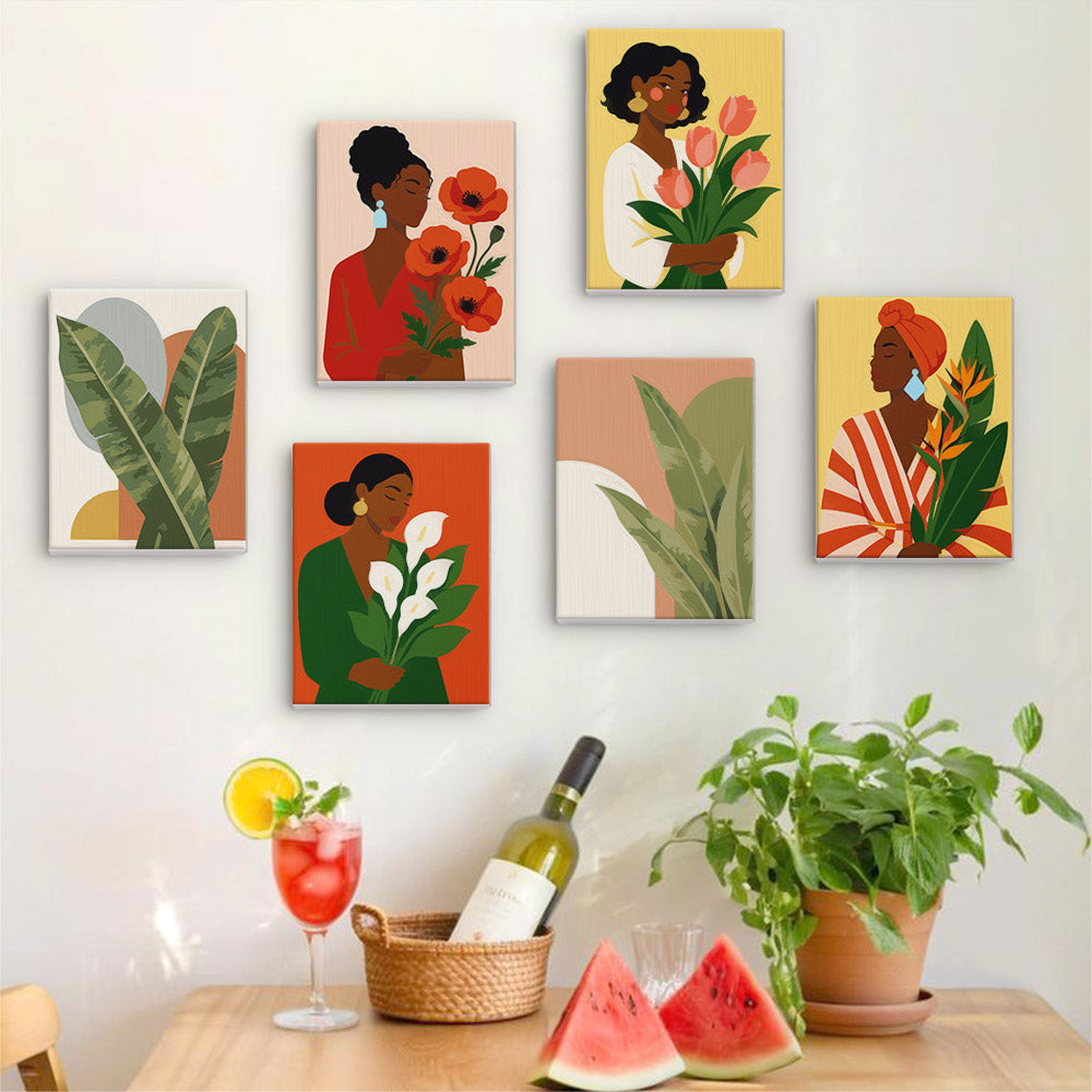 Six finished Blooming Muses mini paintings hung on a wall above a table