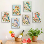 Six finished Blossom Birds mini paintings hung on a wall above a table