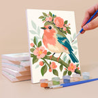 Painting a Blossom Birds mini canvas propped up beside numbered acrylic paints