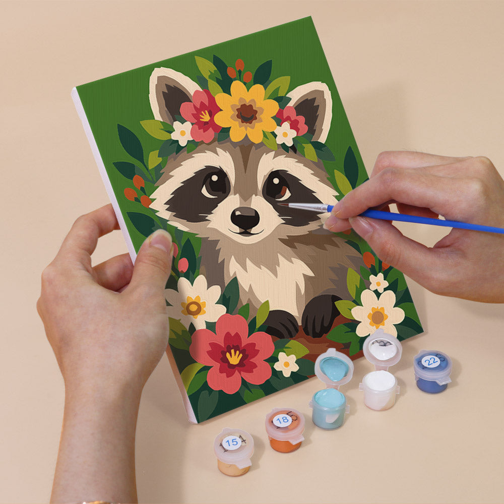 Hand holding a Blossom Critters mini canvas while painting the details