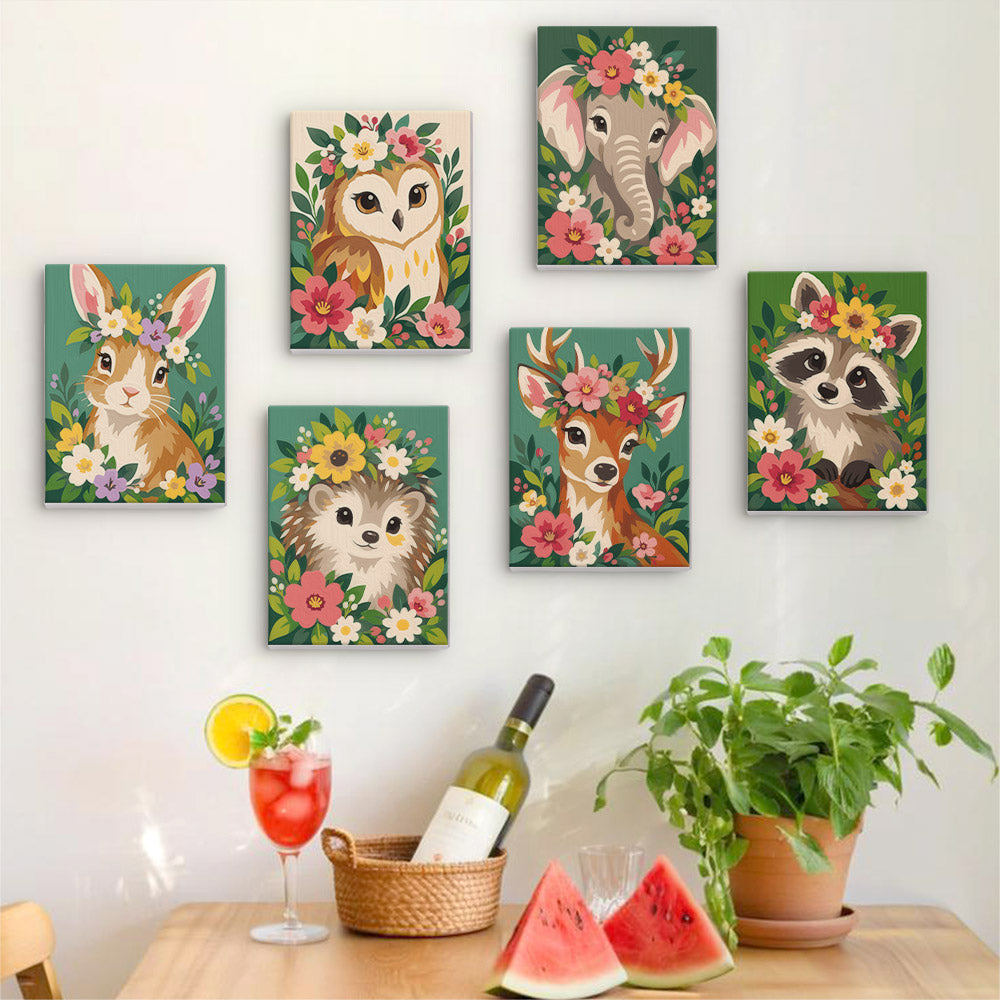 Six finished Blossom Critters mini paintings hung on a wall above a table