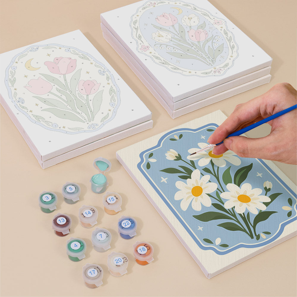 Painting one of the Blue Folk Florals designs next to a stack of mini canvases