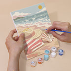 Hand holding a Blush Beach House mini canvas while painting the details