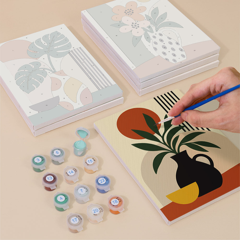 Painting one of the Boho Botanica designs next to a stack of mini canvases