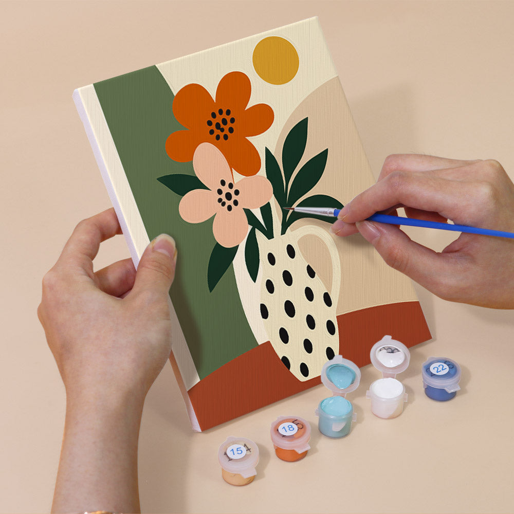 Hand holding a Boho Botanica mini canvas while painting the details