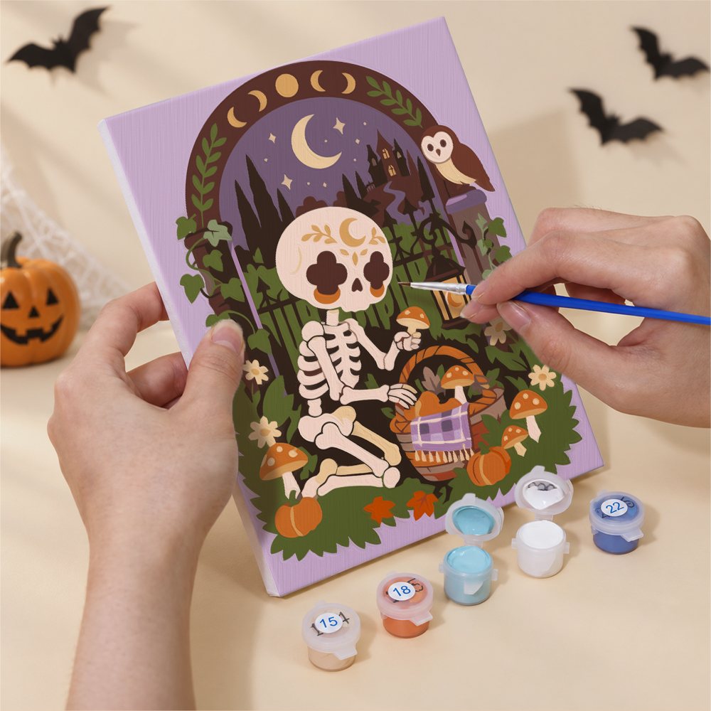 Hand holding a Boho Skeleton Hideaways mini canvas while painting the details