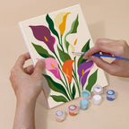 Hand holding a Bold Botanicals mini canvas while painting the details