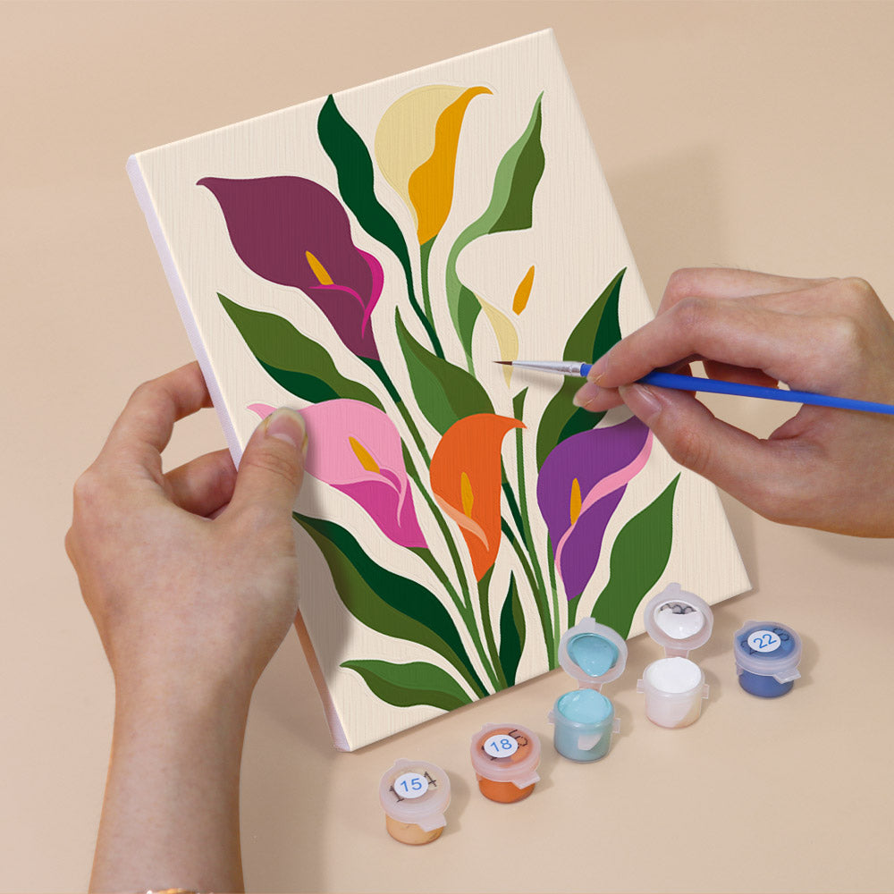 Hand holding a Bold Botanicals mini canvas while painting the details