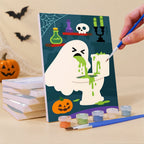 Painting a Boo Bathroom Buddies mini canvas propped up beside numbered acrylic paints