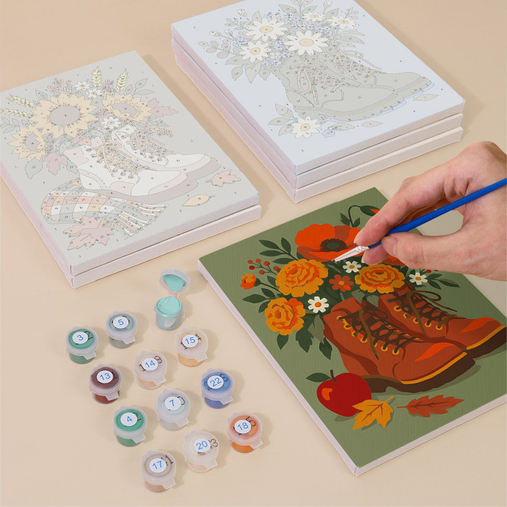Painting one of the Boot Bouquets designs next to a stack of mini canvases