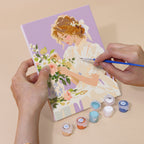 Hand holding a Bouquet Belles mini canvas while painting the details