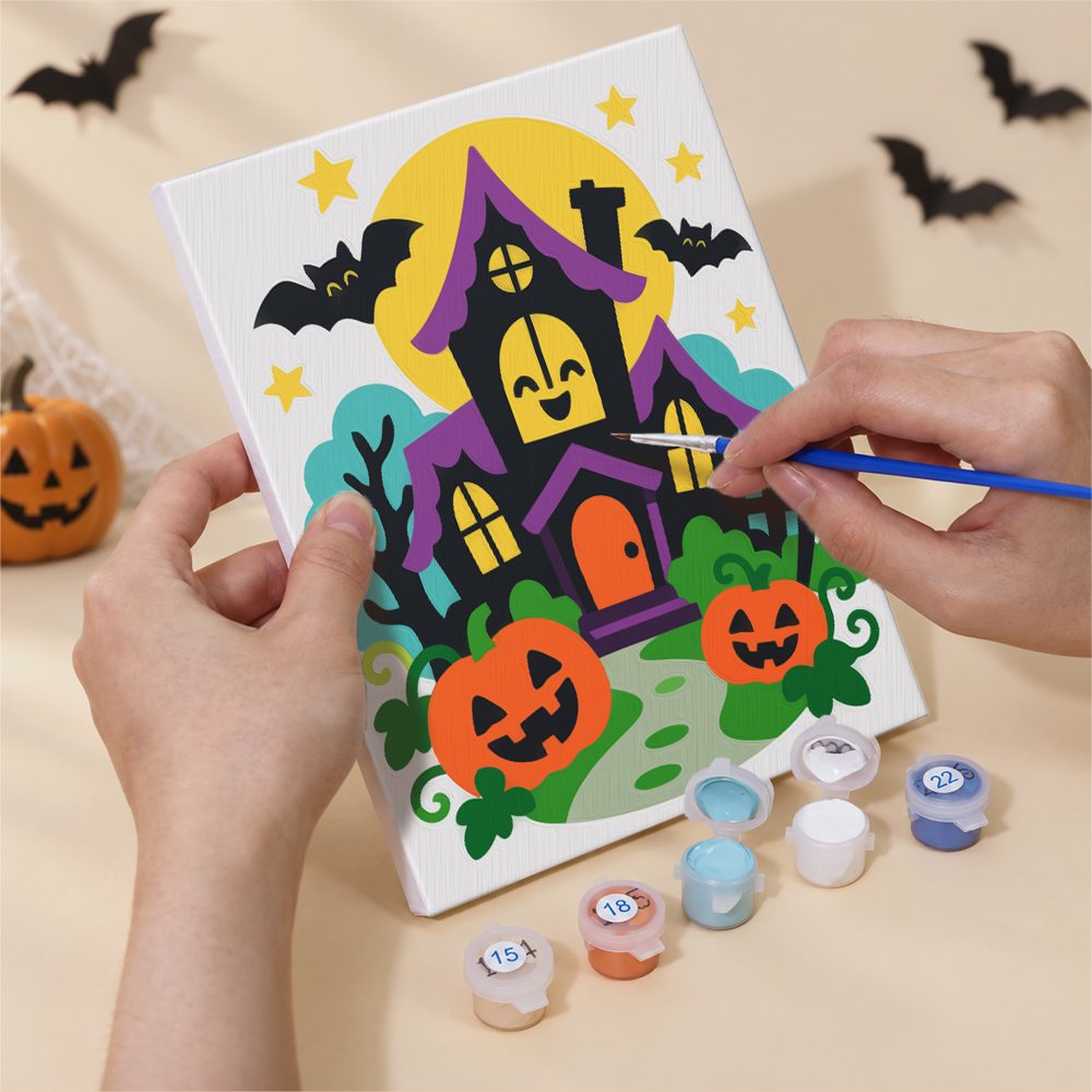Hand holding a Bright Halloween Buddies mini canvas while painting the details