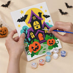 Hand holding a Bright Halloween Buddies mini canvas while painting the details