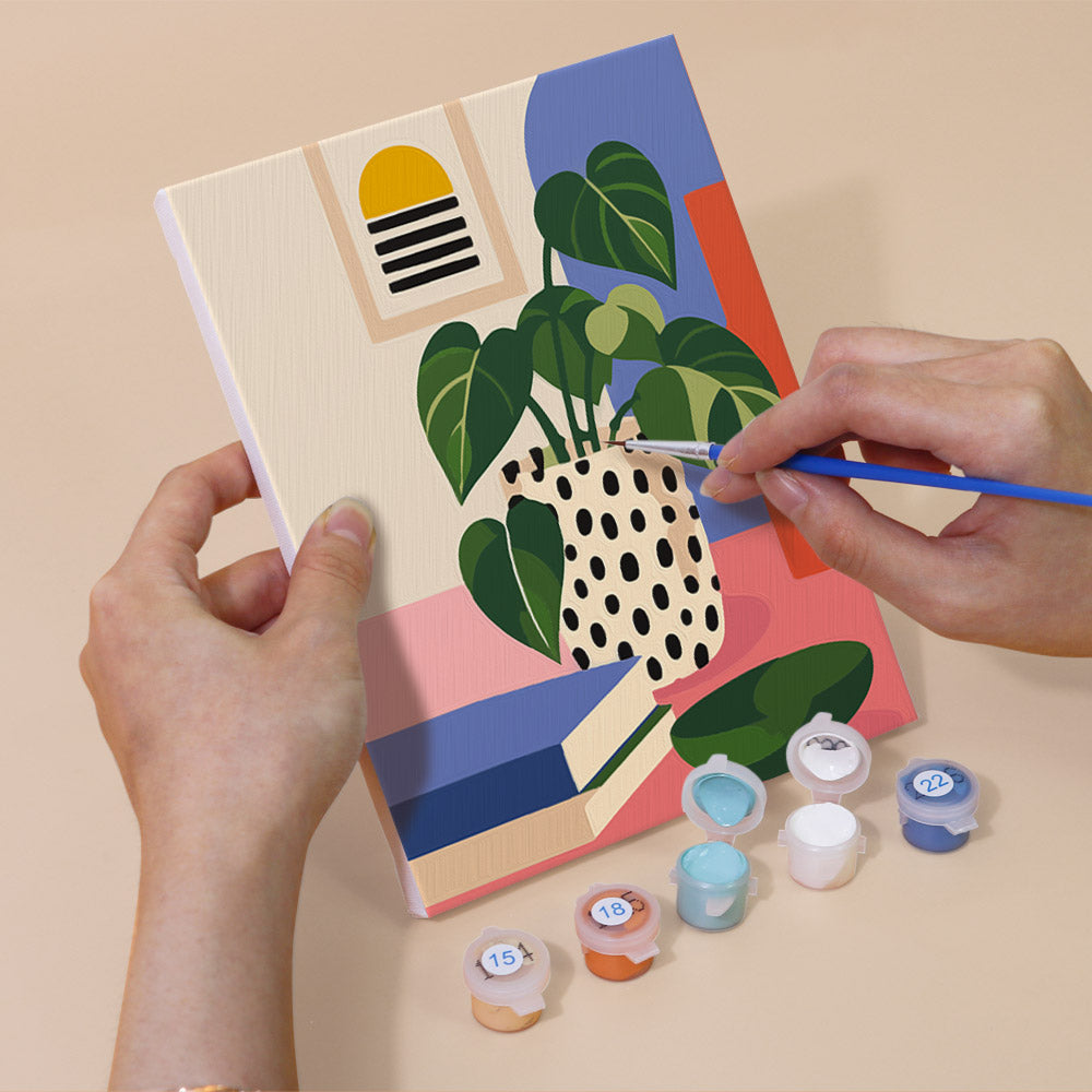 Hand holding a Bright Interiors mini canvas while painting the details