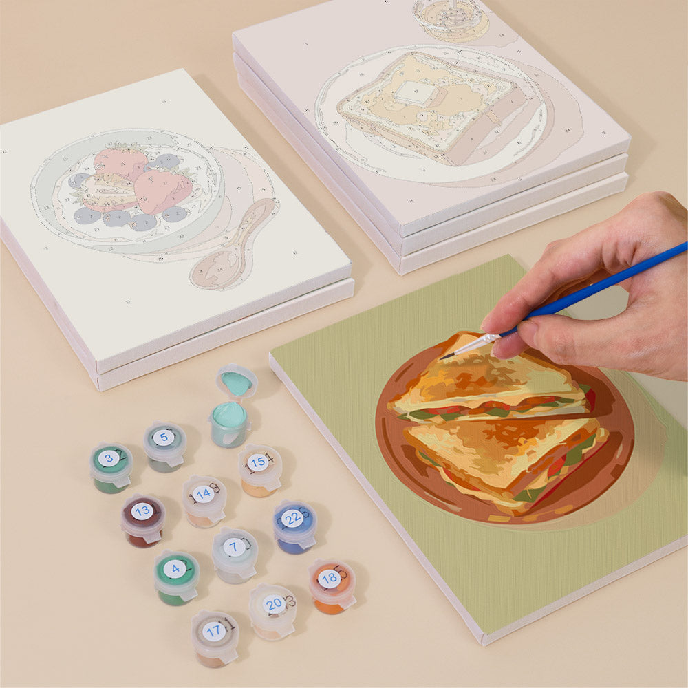 Painting one of the Brunch Club designs next to a stack of mini canvases