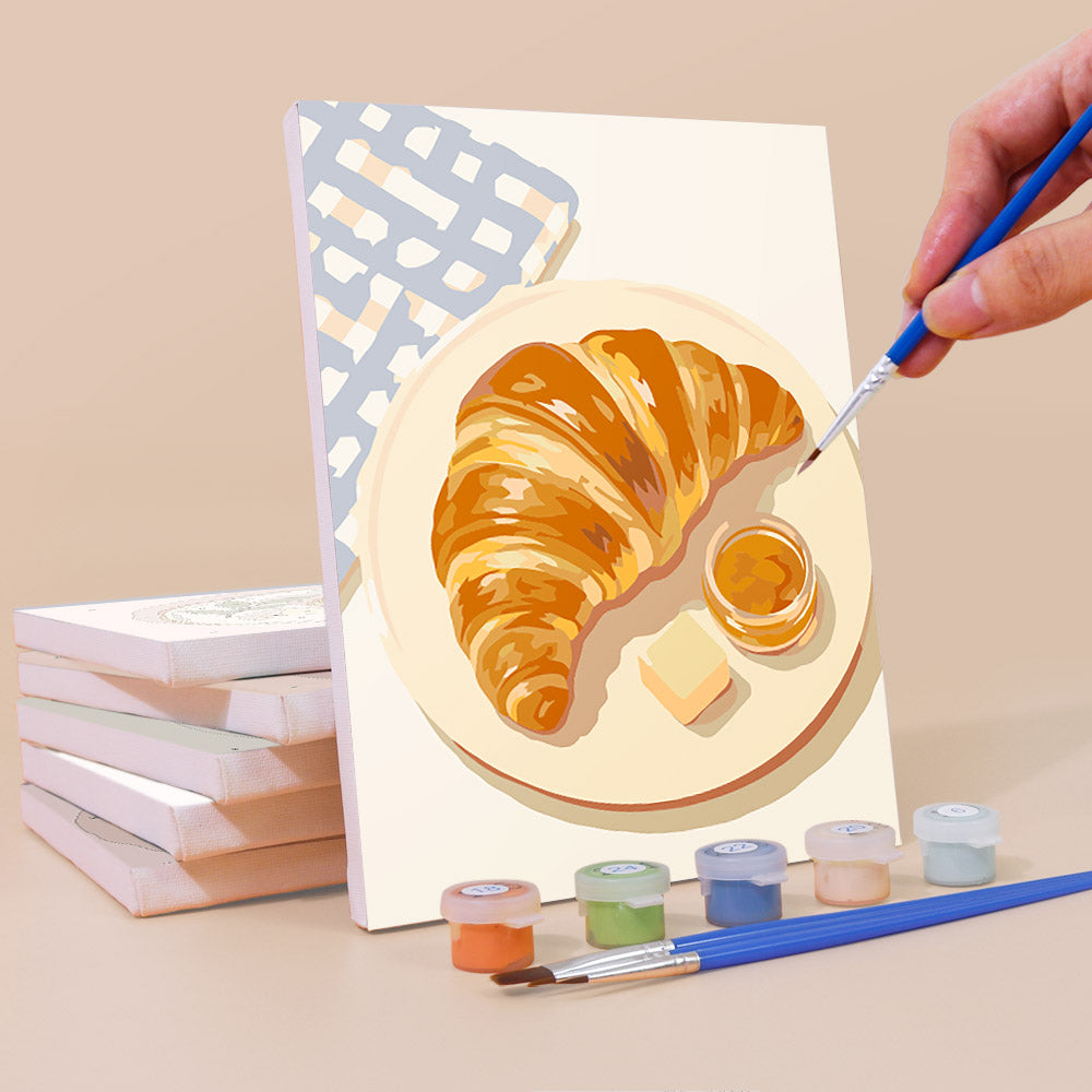 Painting a Brunch Club mini canvas propped up beside numbered acrylic paints