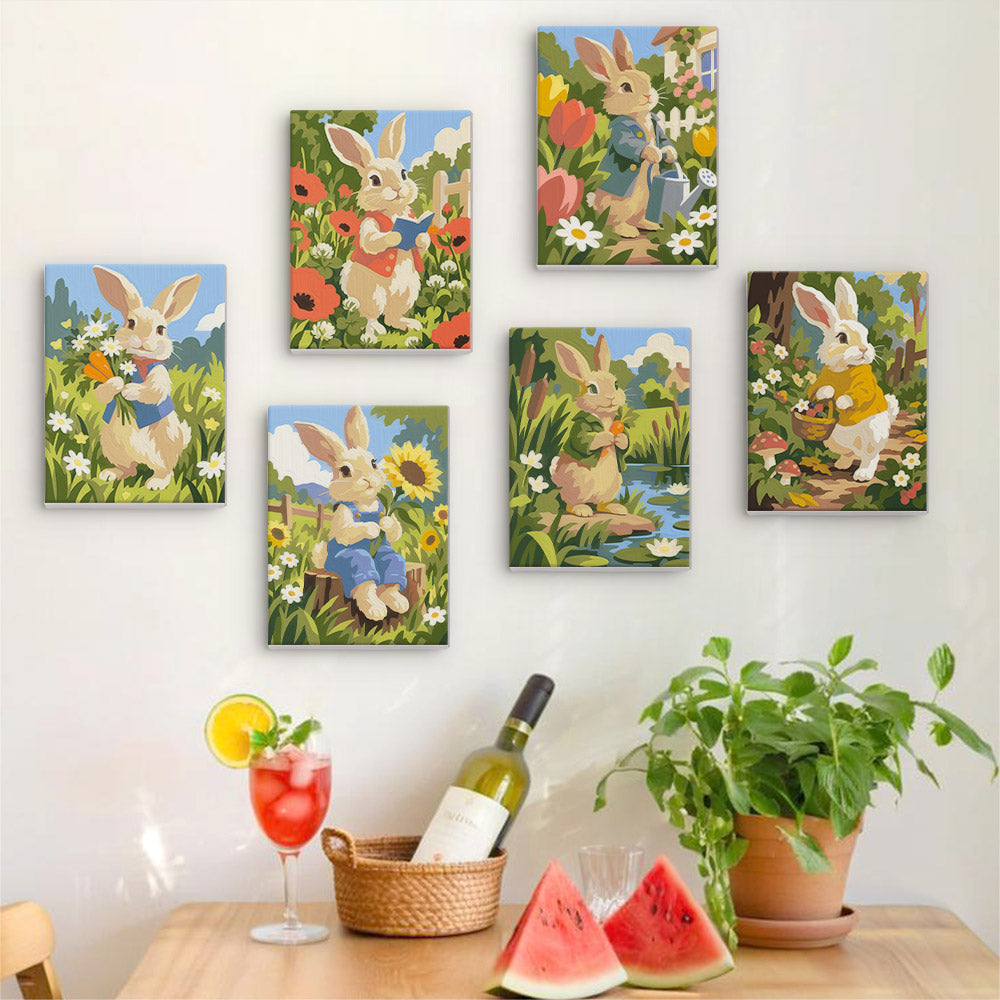 Six finished Bunny Garden mini paintings hung on a wall above a table
