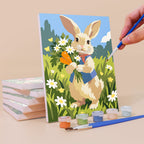 Painting a Bunny Garden mini canvas propped up beside numbered acrylic paints