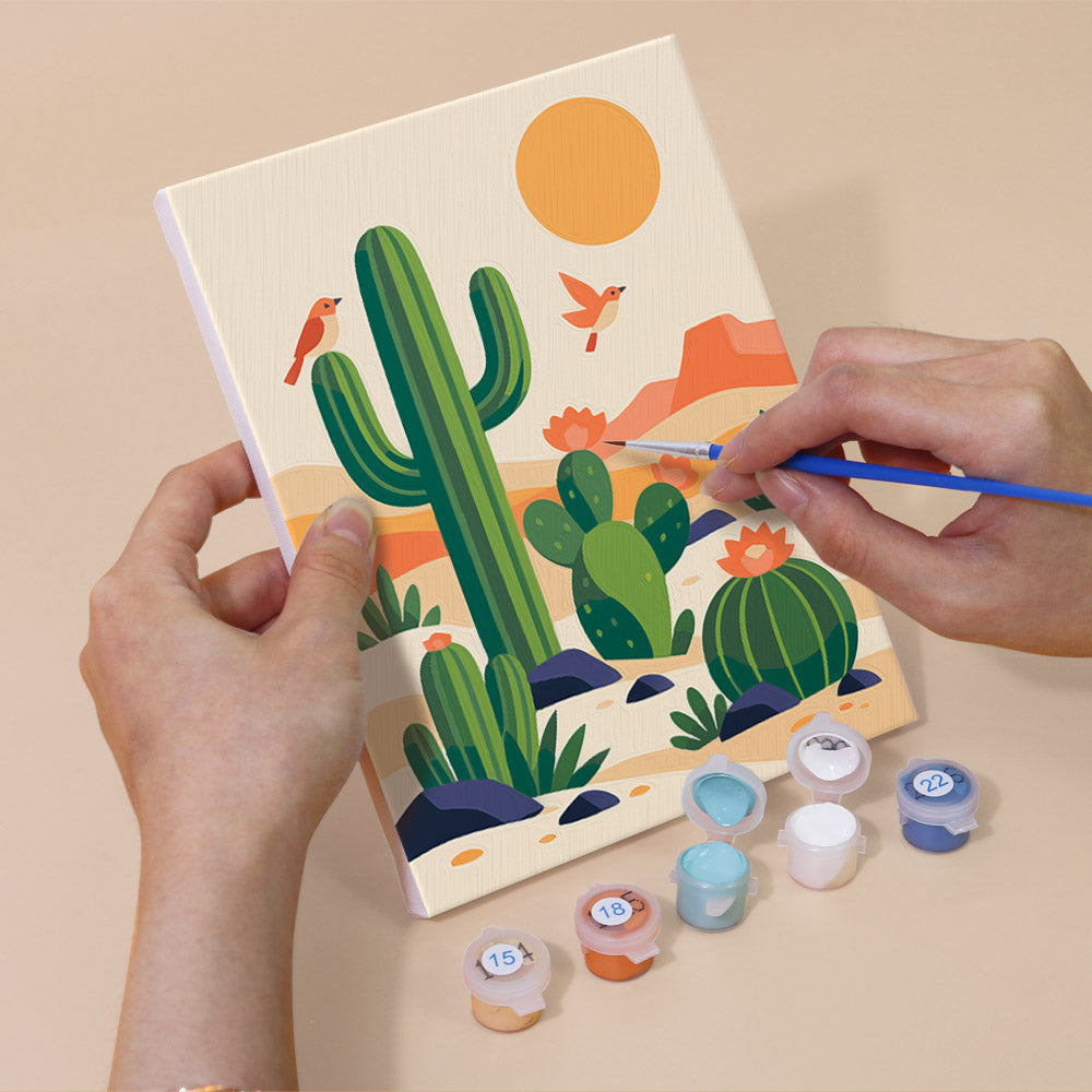 Hand holding a Cactus Country mini canvas while painting the details