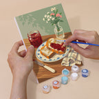 Hand holding a Café Mornings mini canvas while painting the details