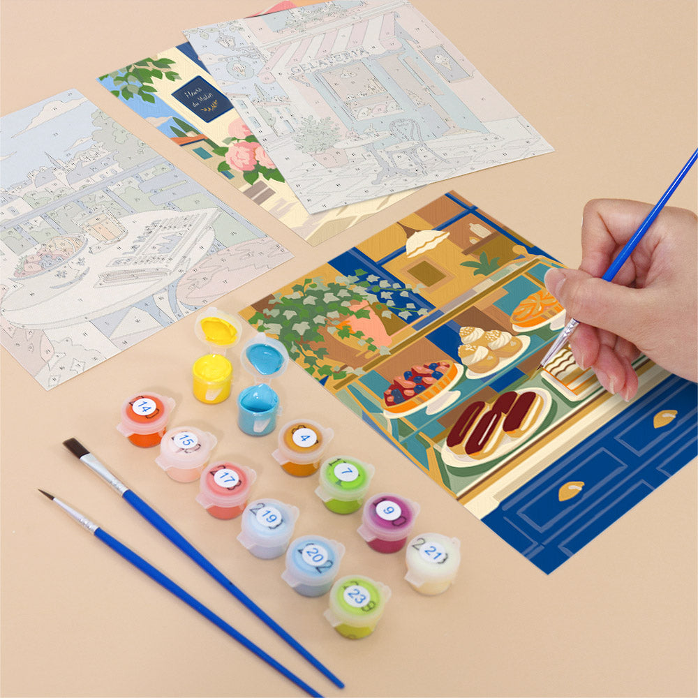 Filling in a Café Mornings mini canvas with numbered acrylic paints and a fine brush