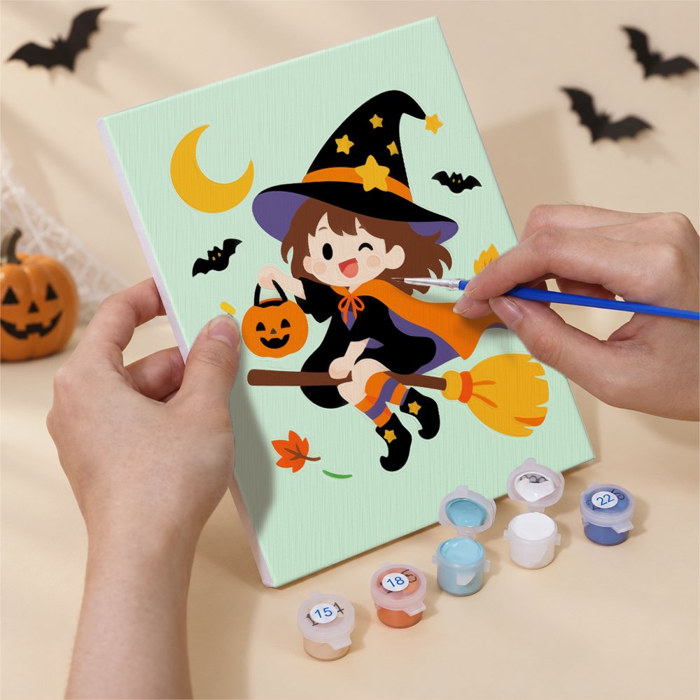 Hand holding a Candy Corn Chibis mini canvas while painting the details