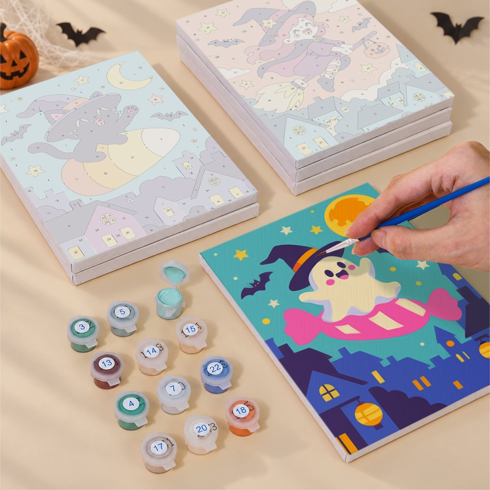 Painting one of the Candy Sky Halloween designs next to a stack of mini canvases
