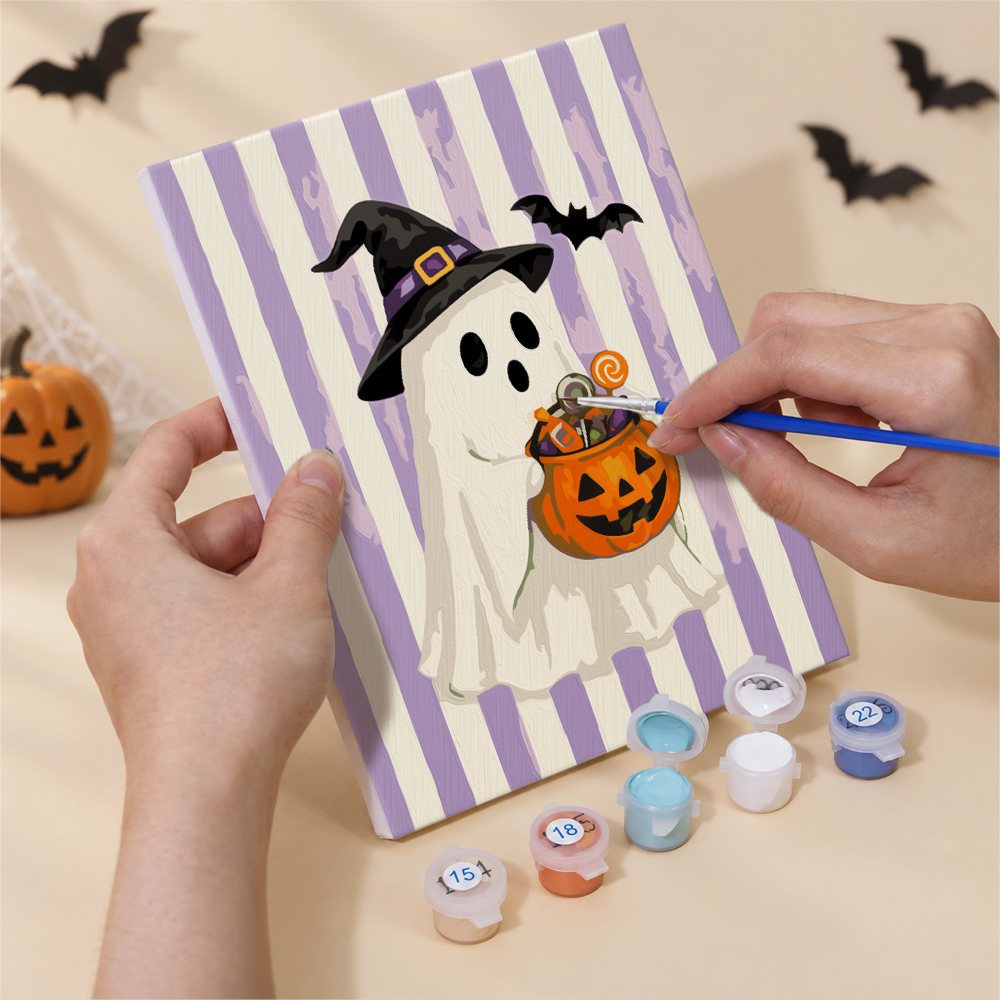 Hand holding a Candy Stripe Spooks mini canvas while painting the details