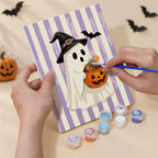 Hand holding a Candy Stripe Spooks mini canvas while painting the details
