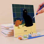 Painting a Cats at Home mini canvas propped up beside numbered acrylic paints