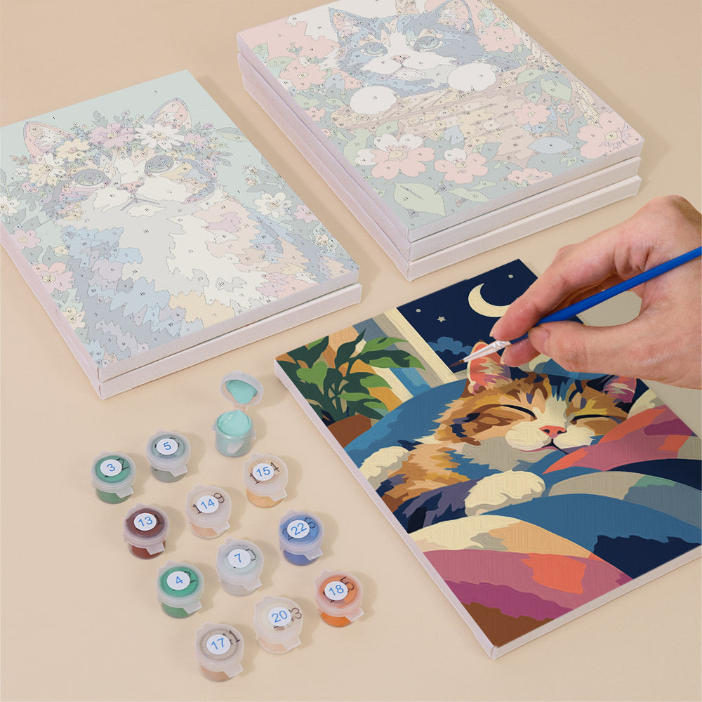 Painting one of the Cats in Bloom designs next to a stack of mini canvases