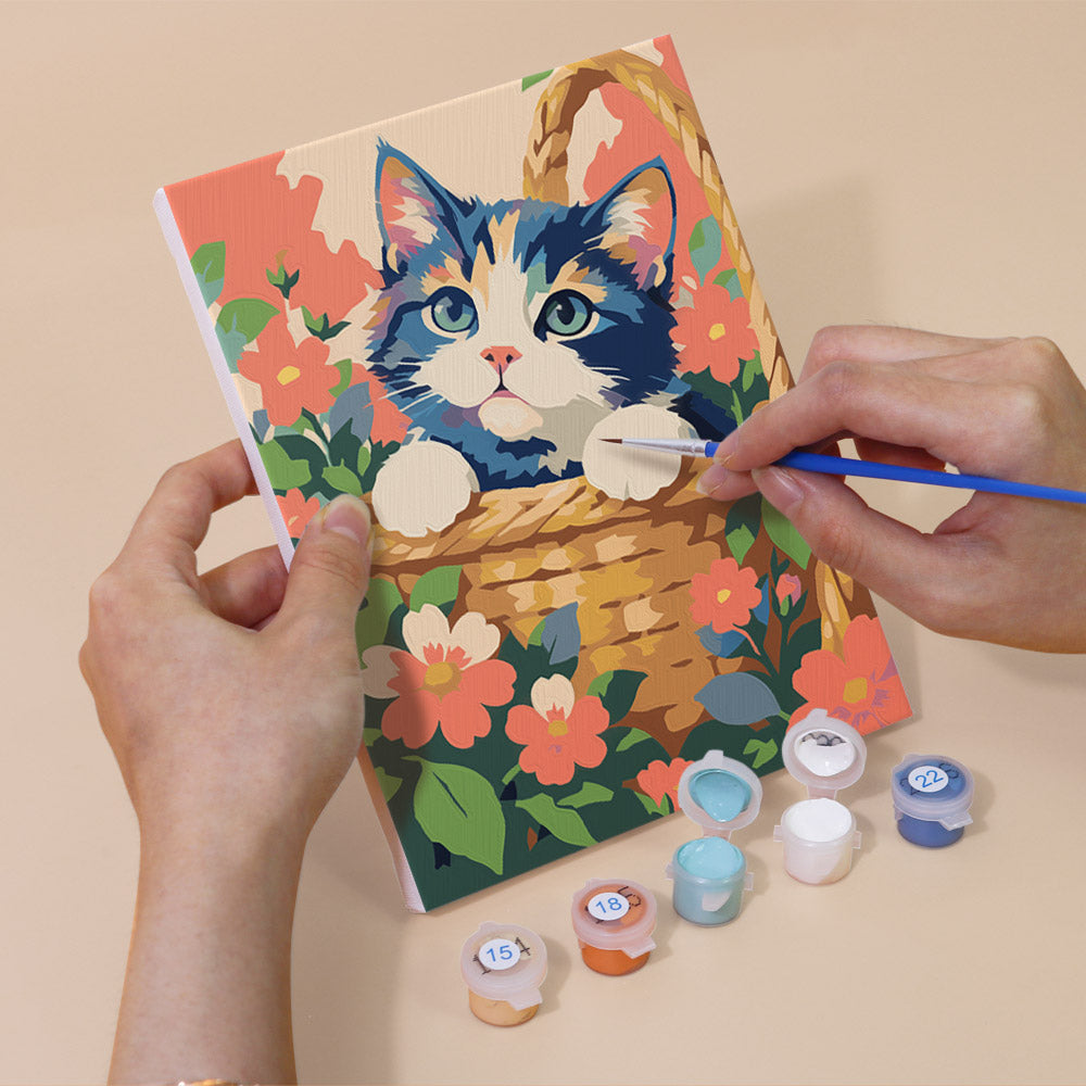 Hand holding a Cats in Bloom mini canvas while painting the details